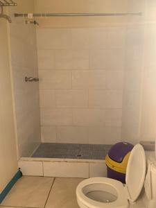 uma casa de banho com um WC e um chuveiro em Paradise Divers Hotel em Útila