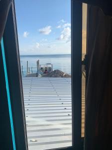 uma vista para o oceano a partir de uma porta em Paradise Divers Hotel em Útila