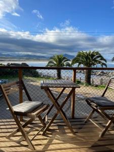 a picnic table and two chairs on a deck at La Ritoqueña Hotel de Playa in Concón
