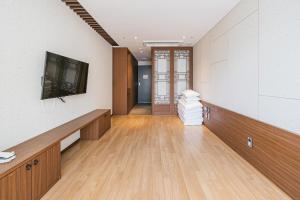 um quarto vazio com uma televisão e um corredor em Hotel Air City Jeju em Jeju