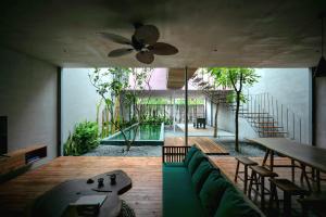 a restaurant with a green couch and a ceiling fan at AnNam Village in Vung Tau