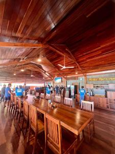 TapokrengにあるAndau Resort Raja Ampatのダイニングルーム(長い木製テーブル、椅子付)