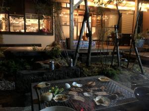a grill with mushrooms on it in front of a building at Yamaganorizou - Vacation STAY 02773v in Yamaga