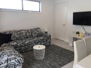 ein Wohnzimmer mit einem Sofa und einem TV in der Unterkunft Sea & Sun Beach House in Norah