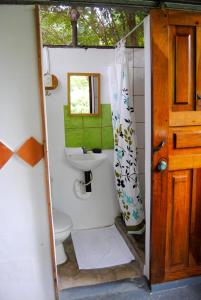 a bathroom with a sink and a toilet and a mirror at Hacienda Sarah in Nosara