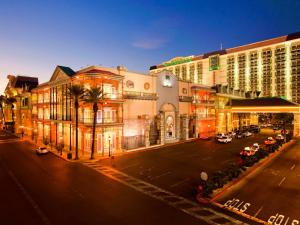 a city street with buildings and palm trees at night at Comfy Unit at Orleans Casino Strip Las Vegas in Las Vegas