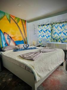 a bedroom with a large bed with a painting on the wall at Playa Blanca Beach Resort in Puerto Galera +88 photos