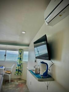 a room with a table with a tv on the wall at Playa Blanca Beach Resort in Puerto Galera