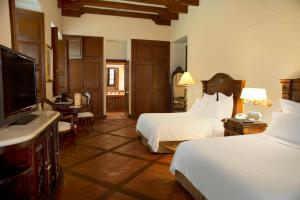 a hotel room with two beds and a flat screen tv at Fiesta Americana Hacienda San Antonio El Puente Cuernavaca in Cuernavaca