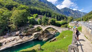 un puente sobre un río con un grupo de personas en él en I viaggi del Lea en Cadenazzo