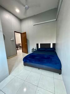 a bedroom with a blue bed in a white room at Impiana Pool House Seri Manjung in Seri Manjung