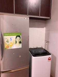 einen Kühlschrank in einer Küche mit einem Plakat darauf in der Unterkunft Impiana Pool House Seri Manjung in Seri Manjung