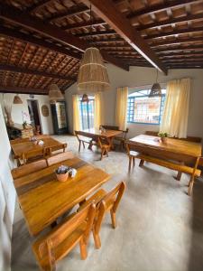 Habitación grande con mesas y bancos de madera. en Pousada Praias do Norte, en São Miguel dos Milagres