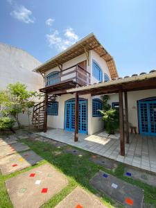 a house with blue shuttered windows and a patio at Pousada Praias do Norte in São Miguel dos Milagres