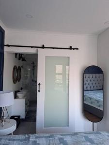 a bedroom with a mirror and a bed and a sink at Modern mountainside home with ocean view - Minimal load shedding in Cape Town
