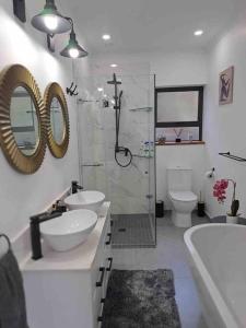 a bathroom with two sinks and a shower and a toilet at Modern mountainside home with ocean view - Minimal load shedding in Cape Town
