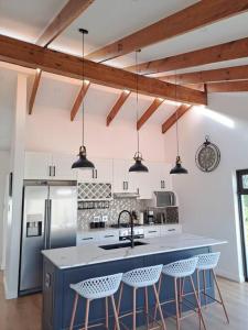 a kitchen with a blue island with bar stools at Modern mountainside home with ocean view - Minimal load shedding in Cape Town