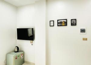 a white wall with a television and pictures on it at Crabby homes in Hanoi