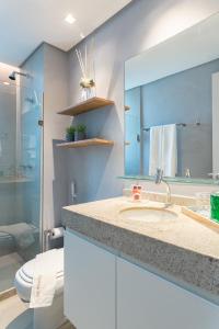 a bathroom with a sink and a toilet and a mirror at Flat de luxo Rooftop 201 in Recife