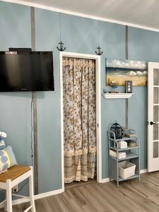 a room with a television and a door with a curtain at Coastal Imagination Oasis in Davenport