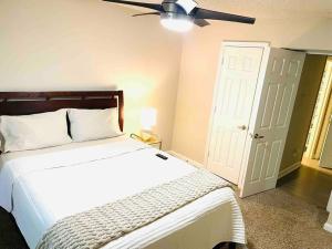 a bedroom with a white bed and a ceiling fan at ATL Entire Apartment: 10 MIN to Everything! in Atlanta