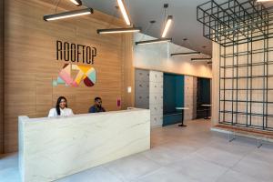 two people sitting at a counter in a lobby at Flat de luxo Rooftop 201 in Recife