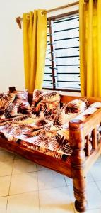 a wooden couch sitting in a room with a window at Casa da Luna Watamu Kenya in Watamu