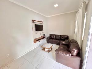uma sala de estar com um sofá de couro e uma televisão em Recanto das Palmeiras - área de lazer em São Carlos em São Carlos