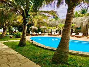 een zwembad met palmbomen en ligstoelen bij Kites Mancora in Máncora +15 foto's