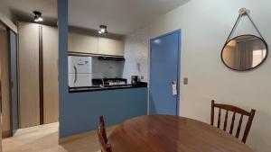 a kitchen with a wooden table and a blue wall at Flat Saint Paul Jardim Paulista Magnifico! in Sao Paulo