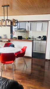 a kitchen with a table and red chairs in a room at Hostel Usaquen Bogota in Bogotá