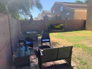 a patio with a table and chairs and a fence at Bella Oasis Family Retreat in El Mirage
