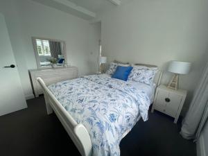 a bedroom with a bed with a blue and white comforter at Character 1920s 3 bedroom bungalow in Cambridge