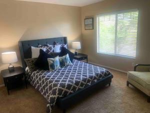 a bedroom with a blue bed with two lamps and a window at Bella Oasis Family Retreat in El Mirage