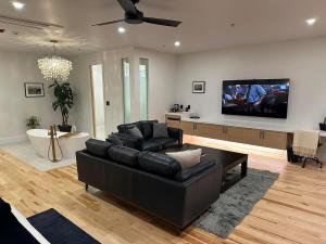 a living room with a black couch and a flat screen tv at Cribs on Main in Picton