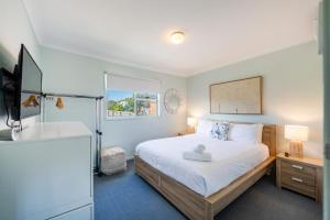 1 dormitorio con cama, bañera y lavamanos en At The Beach Brooms Head-LJHooker Yamba en Brooms Head