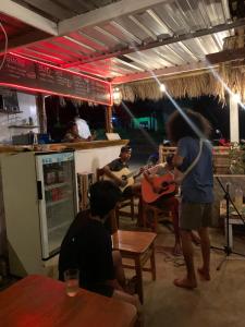a group of people sitting in a restaurant playing guitar at Dragonfly Senaru Lodge in Senaru
