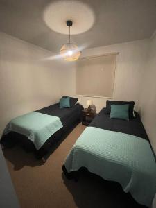 een slaapkamer met 2 bedden en een lamp bij Depto hermoso El Tabo in El Tabo
