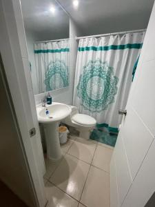 a bathroom with a sink and a toilet and a shower curtain at Depto hermoso El Tabo in El Tabo