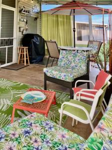un patio con sillas, una mesa y una sombrilla en Coastal Imagination Oasis, en Davenport
