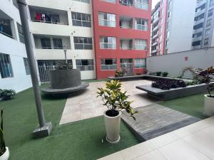 een binnenplaats in een gebouw met potplanten en gebouwen bij Acogedor apartamento centrico, tranquilo con piscina in Lima