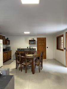 uma cozinha com uma mesa e cadeiras e um frigorífico em CASA DA FONTE em Bento Gonçalves