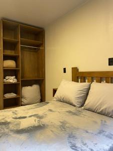 - une chambre avec un grand lit et des oreillers blancs dans l'établissement CASA DA FONTE, à Bento Gonçalves