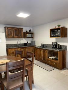 eine Küche mit Holzschränken und einem Holztisch mit einer Tableasteryasteryastery in der Unterkunft CASA DA FONTE in Bento Gonçalves
