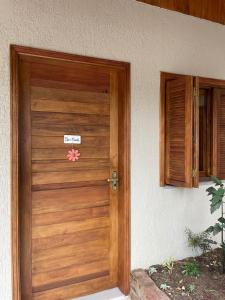 une porte en bois d'une maison munie d'un panneau. dans l'établissement CASA DA FONTE, à Bento Gonçalves