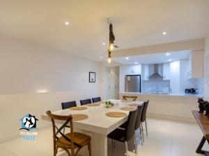 a kitchen and dining room with a white table and chairs at Spectacular Esplanade 4BR Contemporary with Views in Aldinga Beach