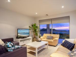 a living room with a couch and a tv at Spectacular Esplanade 4BR Contemporary with Views in Aldinga Beach