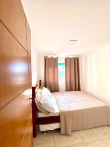 a small bedroom with a bed and a window at Apartamento Apês do Peró 10 - centro - 5 pessoas in Cabo Frio
