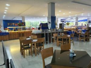 um restaurante com mesas e cadeiras e uma cafetaria em Golden Dolphin Resort - Caldas Novas - GO em Caldas Novas