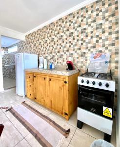 uma cozinha com um fogão e um frigorífico em Apartamento Apês do Peró 10 - centro - 5 pessoas em Cabo Frio